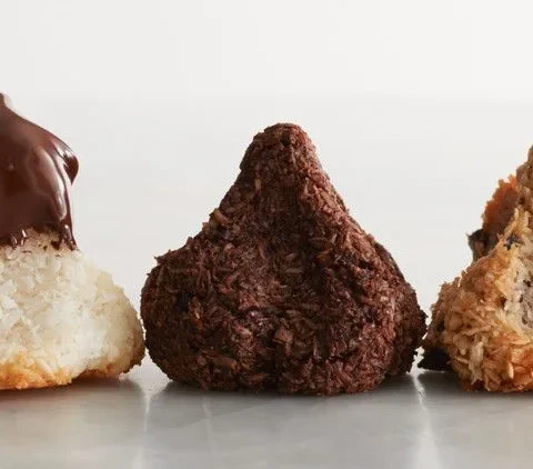 Golden coconut macaroons shaped into pyramids on parchment paper, Martha Stewart coconut macaroons recipe