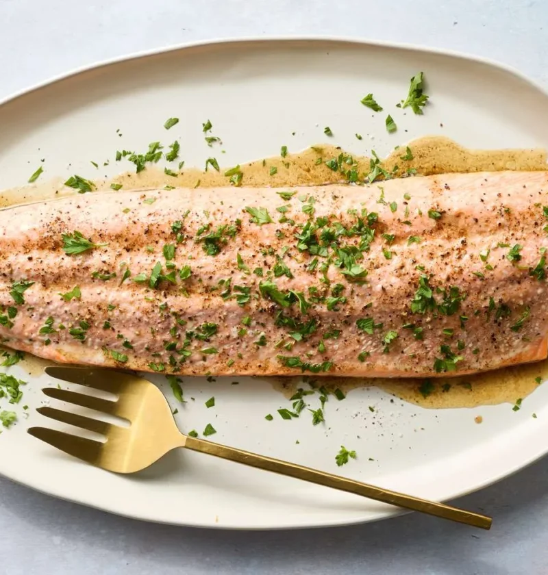 Roasted salmon with butter on a baking sheet, golden crispy skin with fresh parsley, martha stewart roasted salmon with butter recipe