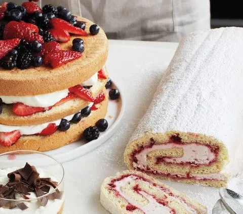 A golden martha stewart sponge cake with a springy crumb, dusted with confectioners sugar on a white plate