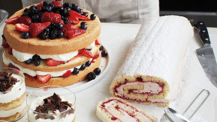A golden martha stewart sponge cake with a springy crumb, dusted with confectioners sugar on a white plate