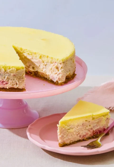 Strawberries-and-cream cheesecake with a glossy roasted strawberry layer and creamy mascarpone top on a graham cracker crust