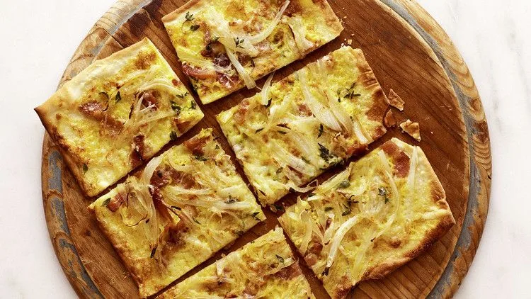 Martha Stewart tarte flambee with crispy bacon, Comte cheese, and slow-cooked onions on paper-thin dough