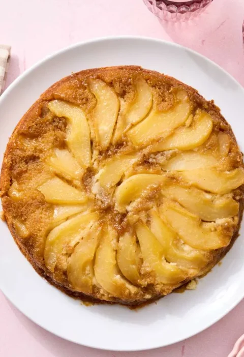 Martha Stewart pear upside-down cake with caramelized brown sugar pear wedges on a golden vanilla cake in a cast-iron skillet