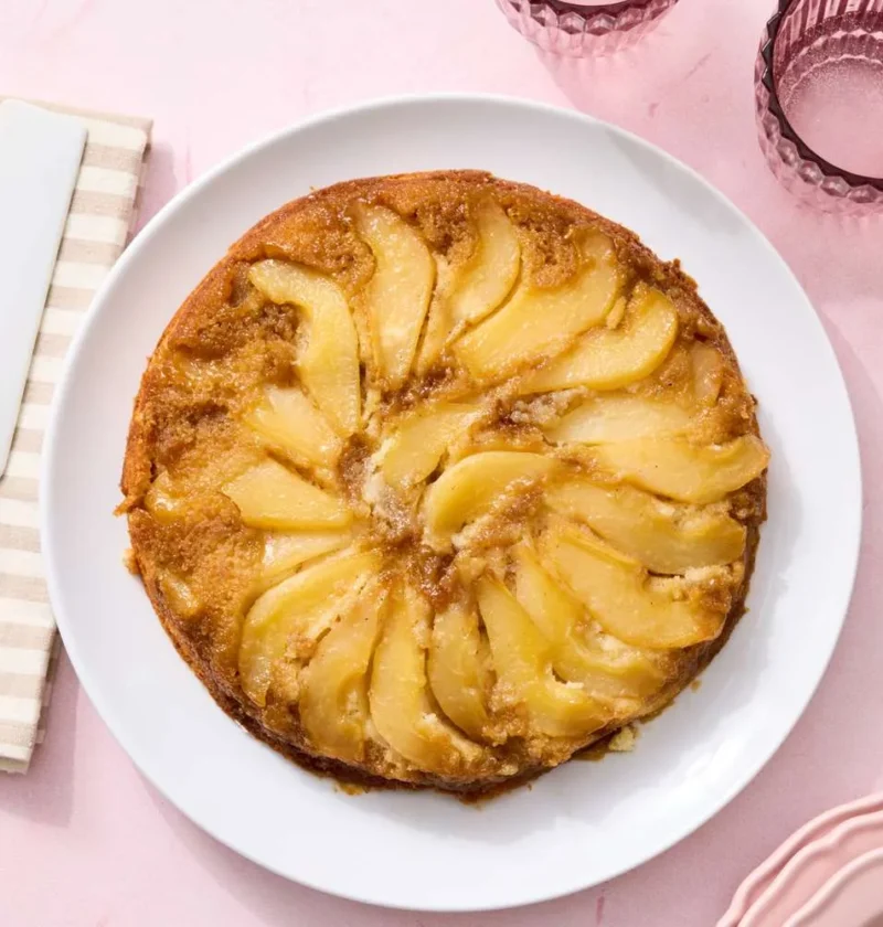 Martha Stewart pear upside-down cake with caramelized brown sugar pear wedges on a golden vanilla cake in a cast-iron skillet