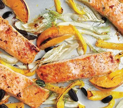 Broiled salmon fillets on a sheet pan with caramelized fennel, yellow bell pepper, and black olives
