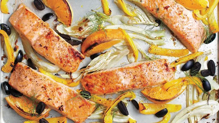 Broiled salmon fillets on a sheet pan with caramelized fennel, yellow bell pepper, and black olives