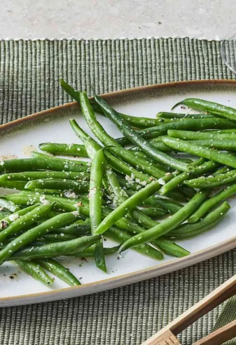 Sautéed green beans glistening with melted butter on a plate, a quick Martha Stewart side dish