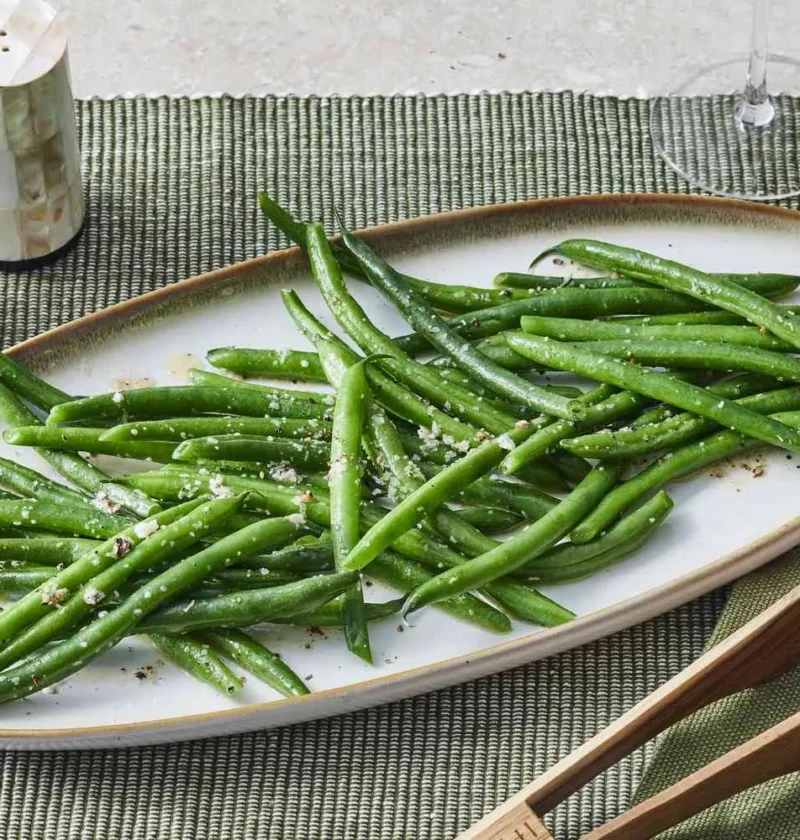 Sautéed green beans glistening with melted butter on a plate, a quick Martha Stewart side dish