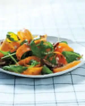 Martha Stewart shaved butternut and carrot salad with dates and sunflower seeds served on a plate over arugula
