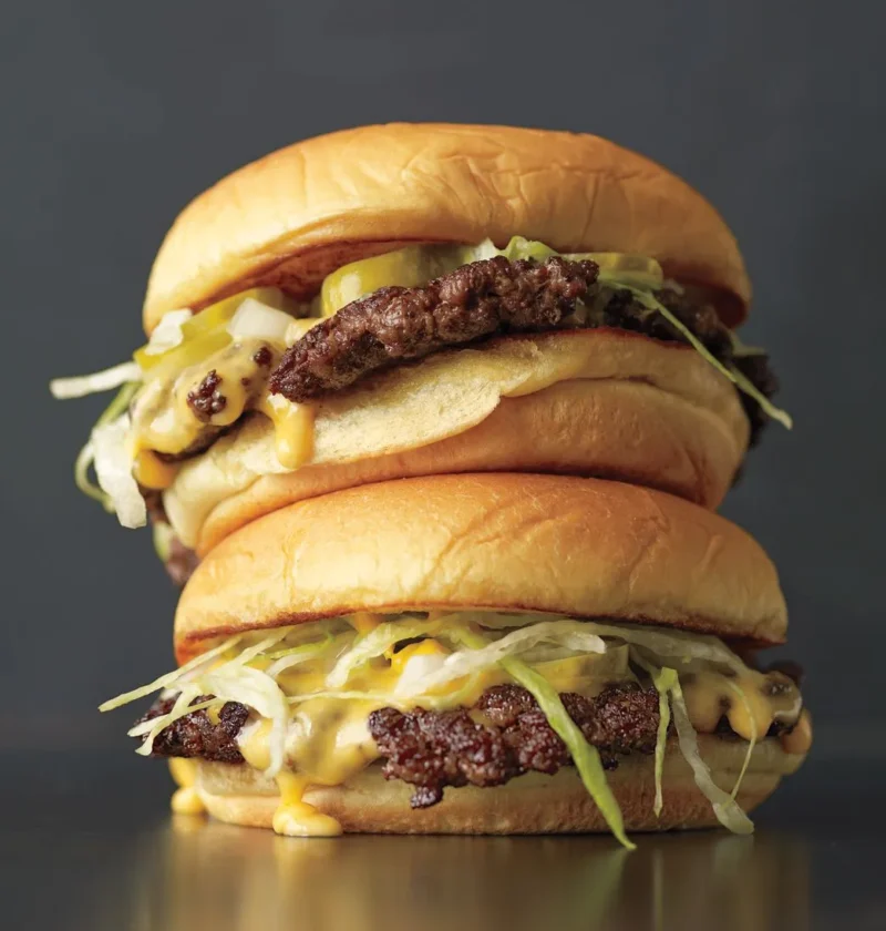 Martha Stewart thin burger with melted American cheese on a toasted potato roll with pickles and lettuce