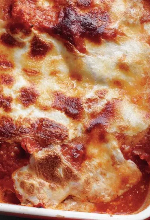 Traditional eggplant parmigiana in a baking dish with bubbling mozzarella and golden Parmesan on top