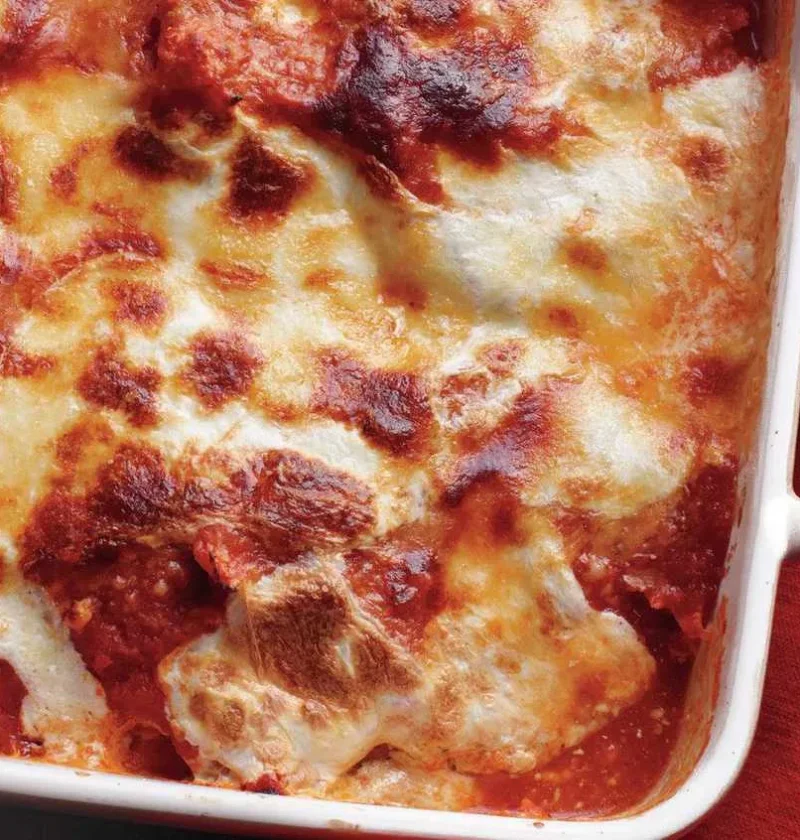 Traditional eggplant parmigiana in a baking dish with bubbling mozzarella and golden Parmesan on top