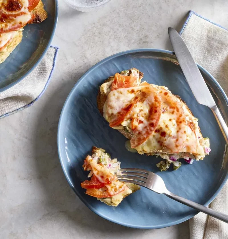 Open-faced martha stewart tuna melts with bubbly provolone and tomato on crusty bread