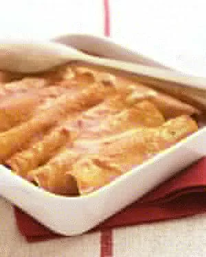 Martha Stewart vegetable enchiladas in a baking dish topped with melted pepper Jack cheese and scallion greens