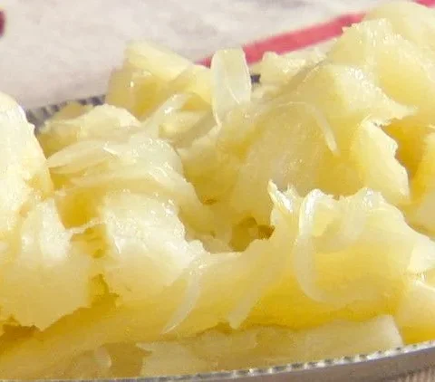 Tender boiled yuca with mojo sauce drizzled over the top on a serving dish