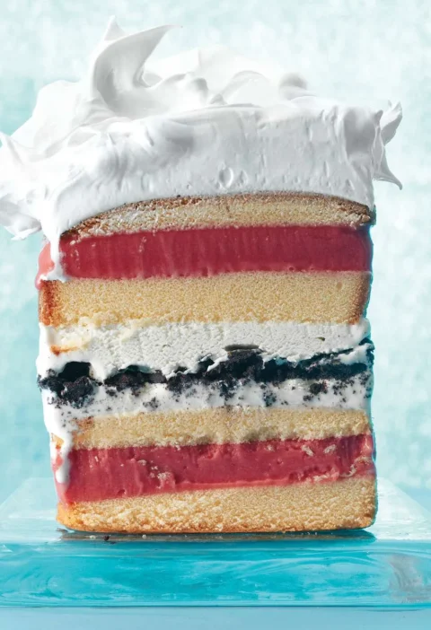 Martha Stewart 7-layer ice cream cake sliced to show pound cake, raspberry sorbet, vanilla ice cream and chocolate cookie layers under meringue