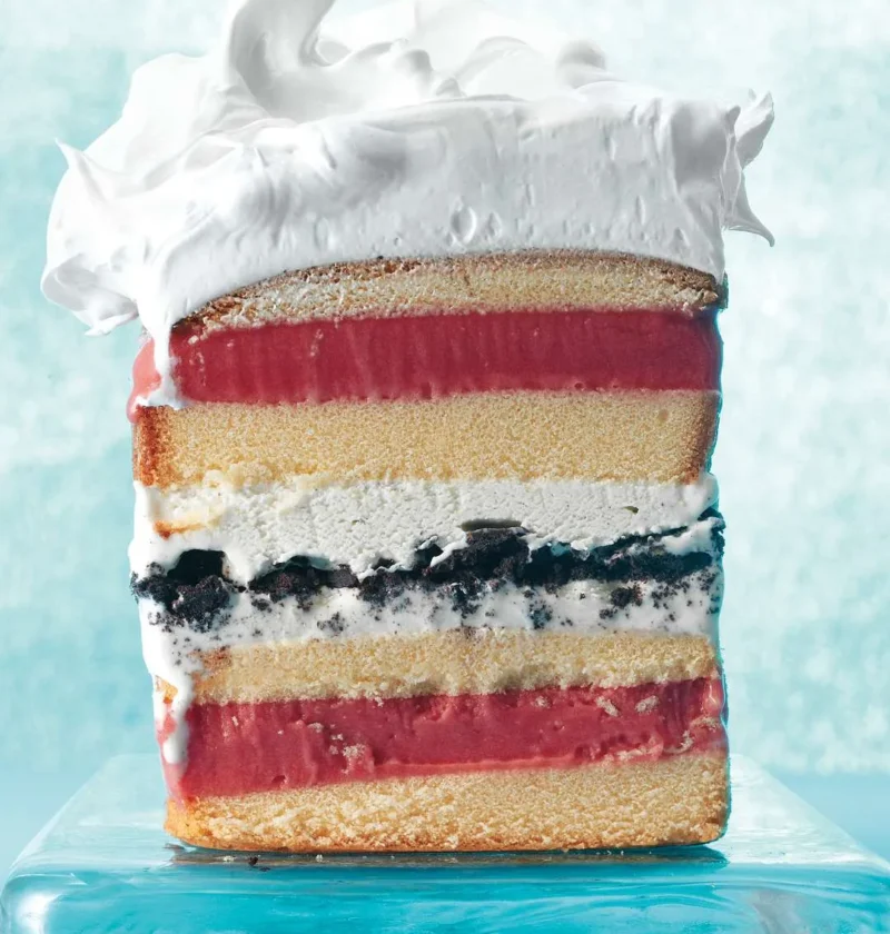 Martha Stewart 7-layer ice cream cake sliced to show pound cake, raspberry sorbet, vanilla ice cream and chocolate cookie layers under meringue