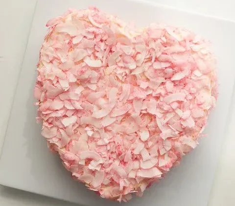 Martha Stewart Alexis' Heart Cake covered in pink coconut flakes on a white square plate