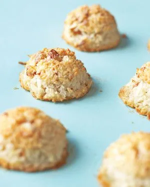 Martha Stewart almond-coconut macaroons with golden toasted edges and chopped almonds on a light blue surface