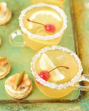 Martha Stewart Amaretto-Bourbon Punch in sugar-rimmed glass mugs garnished with lemon slices and Maraschino cherries