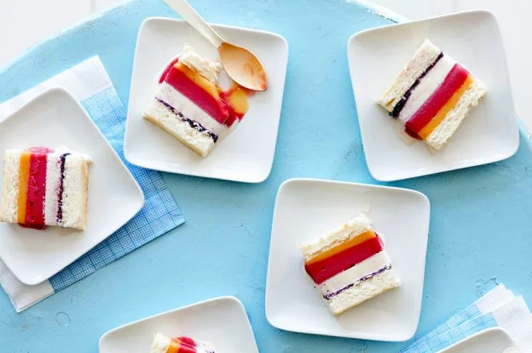 Slices of striped ice cream cake with angel food cake layers on white square plates, an example of Martha Stewart angel food sheet cake for striped ice cream cake