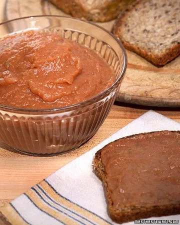 Martha Stewart apple butter in a glass bowl next to a slice of whole grain toast spread with apple butter