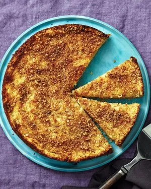 Martha Stewart apple matzo cake with a golden pecan topping on a turquoise plate with three slices cut
