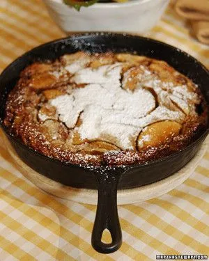 Martha Stewart apple pancakes baked in a cast-iron skillet, puffed and golden with a dusting of powdered sugar