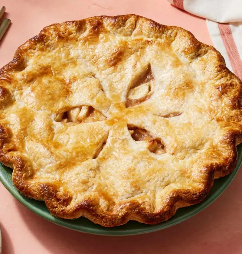 Martha Stewart apple pie crust recipe baked golden brown with a fluted edge and slits on a green pie plate