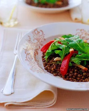 Martha Stewart arugula salad with French lentils, smoked chicken and roasted red pepper strips on a decorative white plate