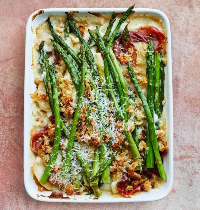 Martha Stewart asparagus-and-potato gratin with prosciutto in a white baking dish topped with breadcrumbs and Pecorino