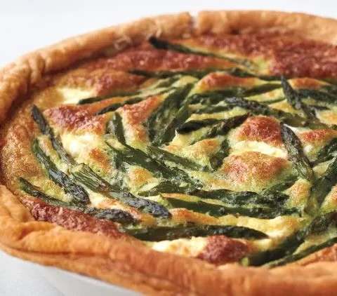 Martha Stewart asparagus custard tart with golden puff pastry crust and asparagus tips arranged on the browned custard