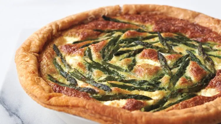 Martha Stewart asparagus custard tart with golden puff pastry crust and asparagus tips arranged on the browned custard