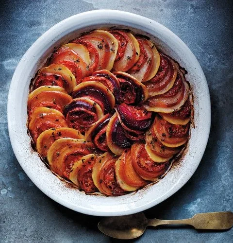 Martha Stewart autumn tian with overlapping slices of red and golden beets, potatoes and tomatoes baked in a round white gratin dish
