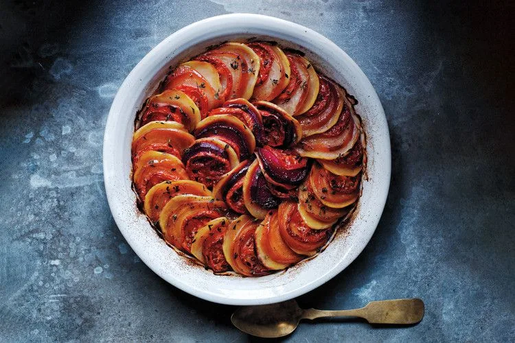 Martha Stewart autumn tian with overlapping slices of red and golden beets, potatoes and tomatoes baked in a round white gratin dish