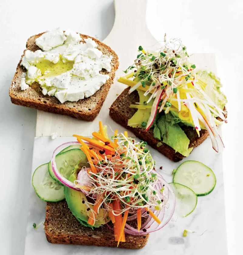 Martha Stewart avocado-and-sprout club sandwiches on whole-grain toast with goat cheese, avocado, sprouts, carrots, cucumber and red onion on a marble board