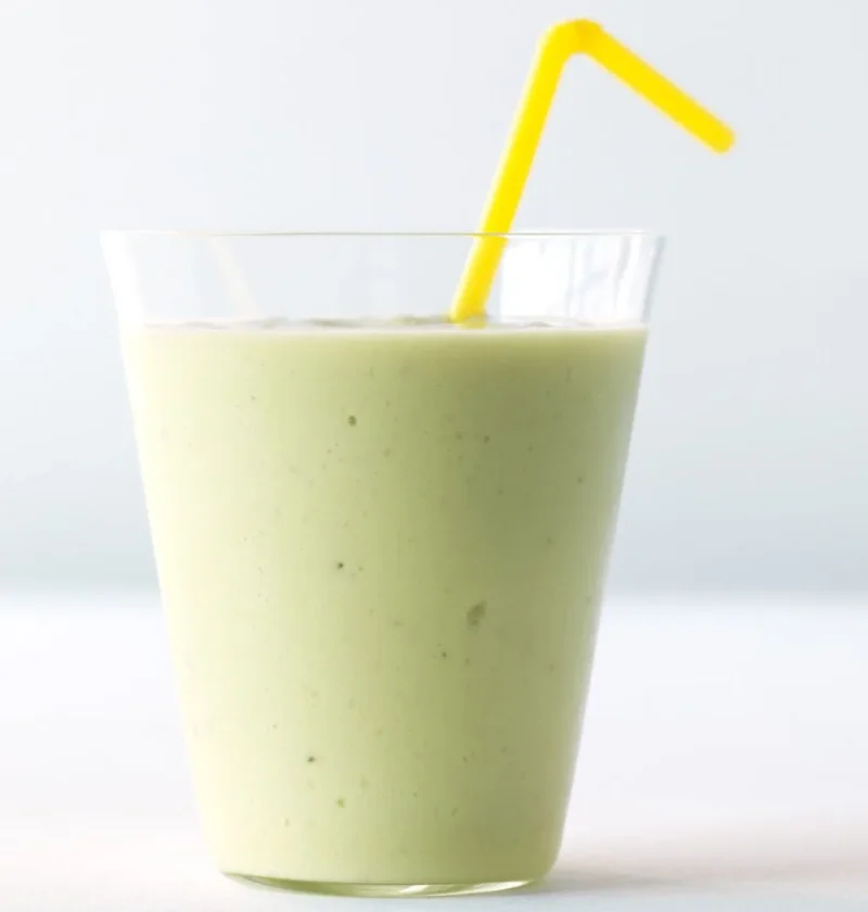 Martha Stewart avocado-banana smoothie in a clear glass with a yellow bendy straw