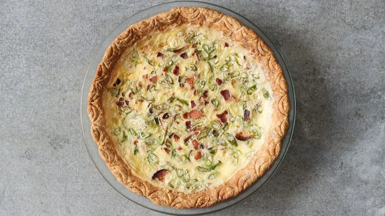 Martha Stewart bacon and scallion quiche in a golden crust topped with crumbled bacon and sliced scallions