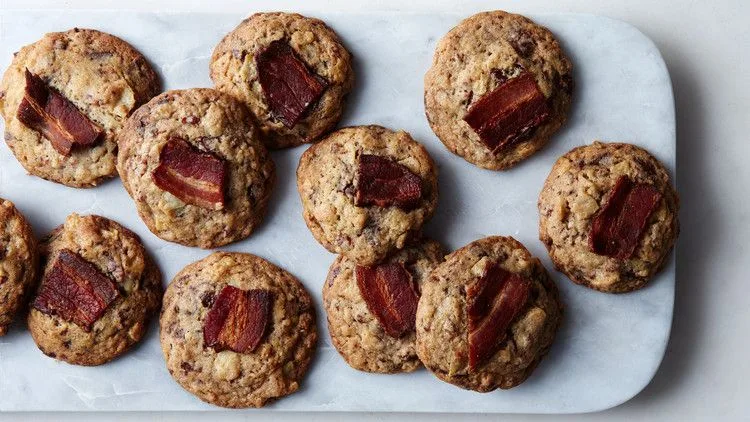 Martha Stewart bacon potato-chip chocolate cookies topped with strips of crispy bacon on a white marble board