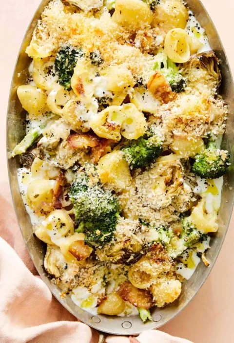 Martha Stewart baked broccoli-and-artichoke shells in an oval dish with golden panko topping, bacon and broccoli florets
