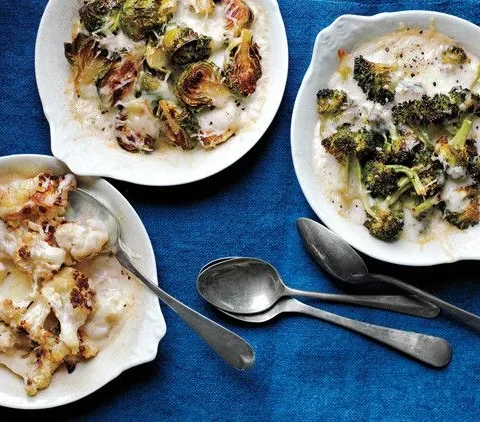 Martha Stewart baked broccoli custards with golden browned Gruyere in white gratin dishes on a blue cloth