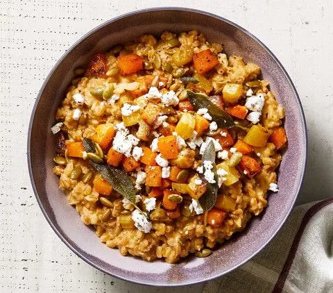 Martha Stewart baked farro risotto with golden roasted squash, beets, sage leaves and crumbled goat cheese in a purple bowl