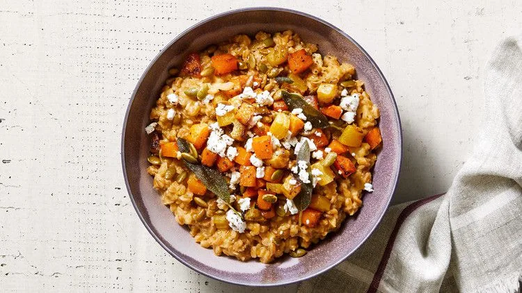 Martha Stewart baked farro risotto with golden roasted squash, beets, sage leaves and crumbled goat cheese in a purple bowl