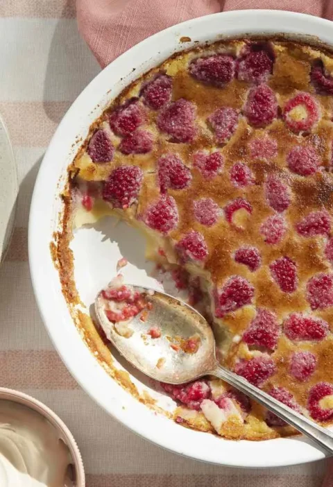 Martha Stewart baked raspberry custard in a white pie plate with a golden top, served with whipped cream