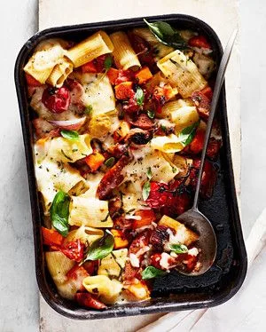 Martha Stewart baked rigatoni with sausage, roasted squash, cherry tomatoes and basil in a dark baking dish