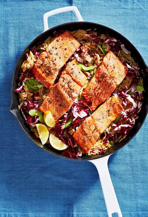 Martha Stewart baked salmon with creamy orzo in a skillet with radicchio and lemon wedges