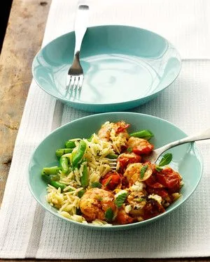 Martha Stewart baked shrimp with tomatoes and feta served over orzo with green beans in a light blue bowl