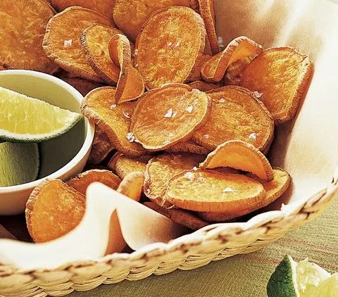 Martha Stewart baked sweet-potato chips in a woven basket with lime wedges on the side