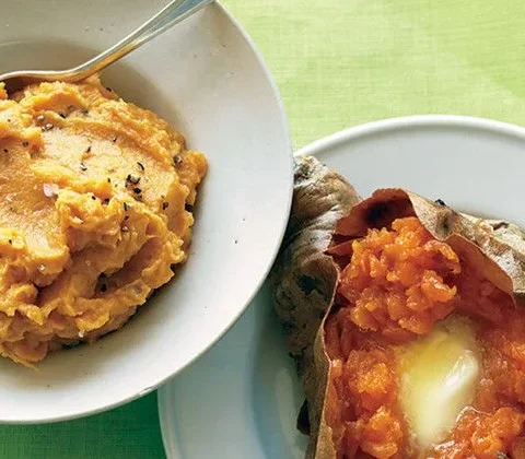 Martha Stewart baked sweet potatoes with brown sugar, one mashed in a white bowl and one split open with melting butter