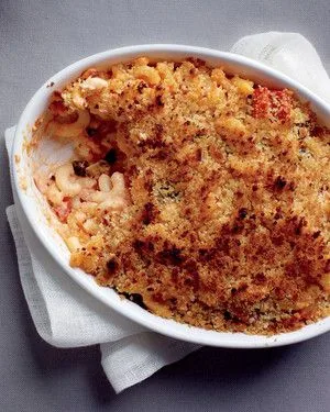 Martha Stewart baked tomato casserole with golden breadcrumb topping and macaroni in a white oval baking dish